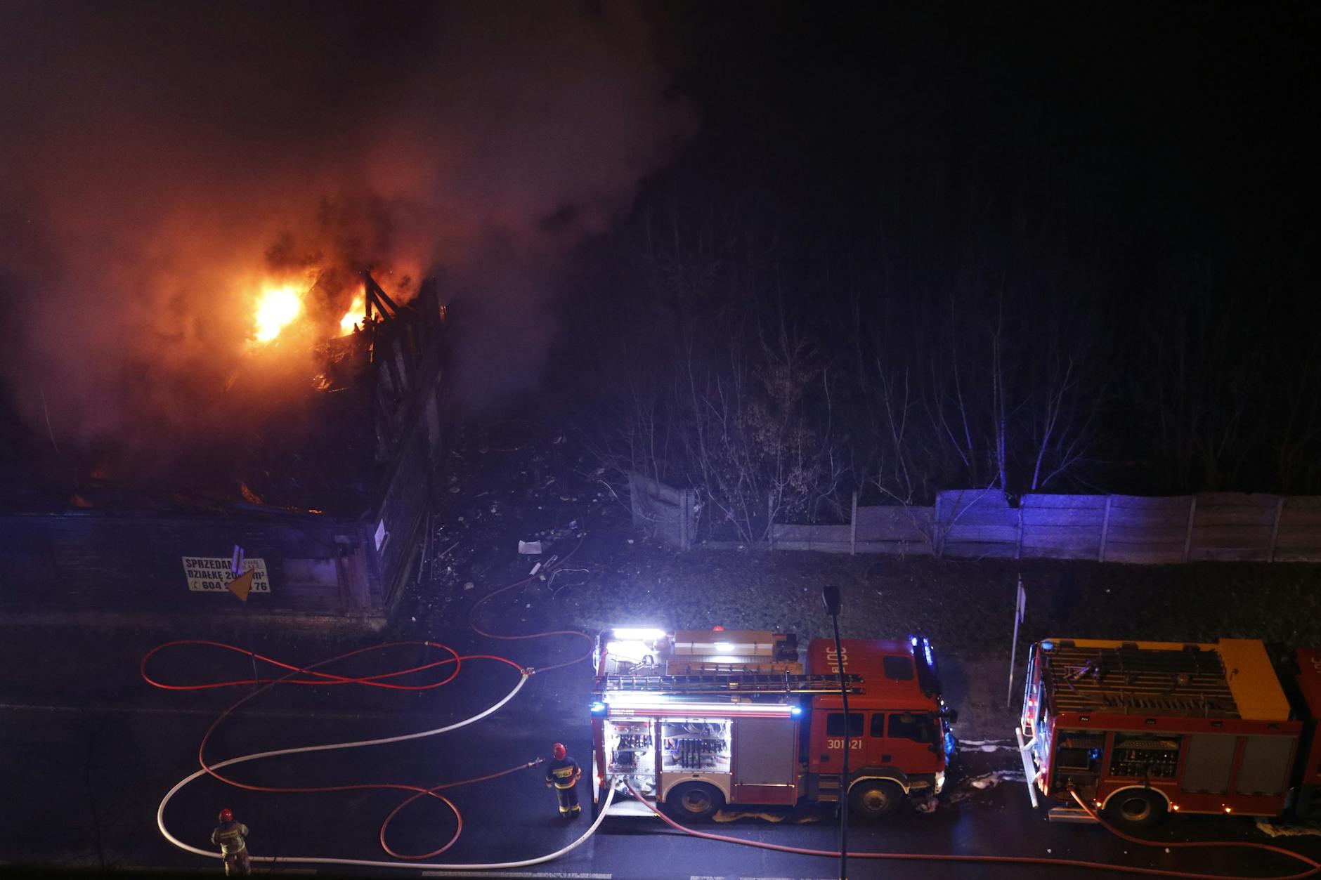 Służby ratownicze gaszą pożar hali pod Poznaniem, widoczny dym i płomienie.